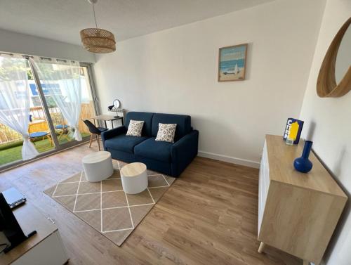 un salon avec un canapé bleu et une table dans l'établissement MOENA Antibes, à Antibes