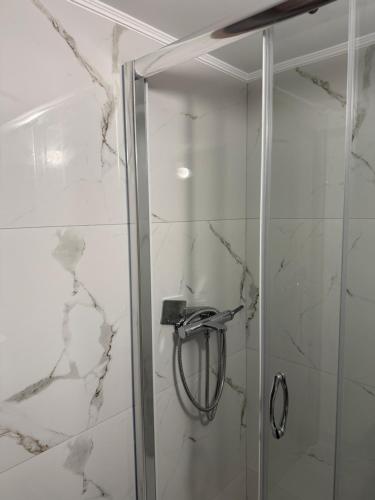 a shower with a glass door in a bathroom at Hotspot Acharnes in Akharnaí