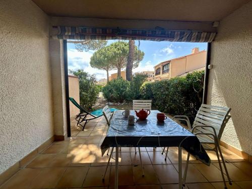 un patio avec une table et des chaises sur un balcon dans l'établissement Appartement studio 2 couchages ST CYPRIEN PLAGE SC070-107, à Saint Cyprien Plage
