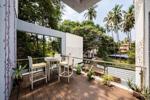 a balcony with a table and chairs on a deck at Helloworld- Calangute- Casa Kiara in Calangute