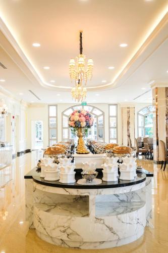 a large room with a table with a vase of flowers at LK Grand Empire in Pattaya South