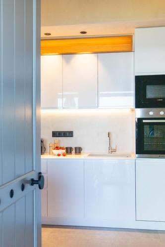a kitchen with white cabinets and a sink at Aquanera Villas - Sunrise View Retreat with Private Pool- 5 minutes from the beach- By Villa Mana Gers in Agii Saranta