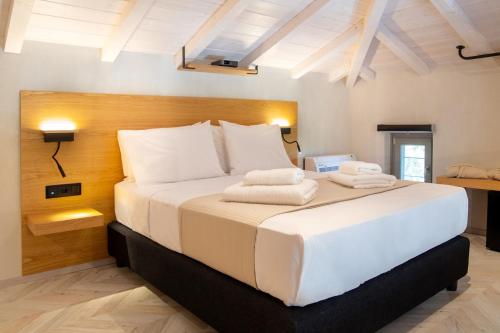 Un dormitorio con una cama grande con toallas. en Aquanera Villas - Sunrise View Retreat with Private Pool- 5 minutes from the beach- By Villa Mana Gers, en Agii Saranta