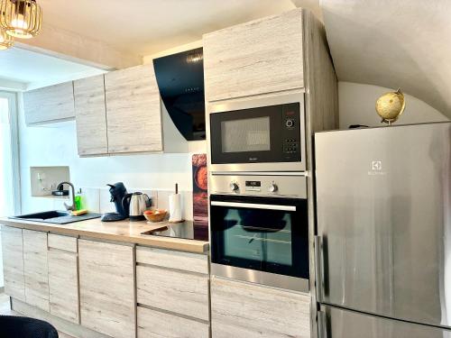 a kitchen with a refrigerator and a microwave at Gîte Molière in Sallèles-dʼAude