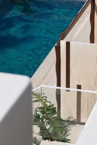 a view of a pool with a chair and water at Iria Blue Mykonos in Platis Yialos Mykonos