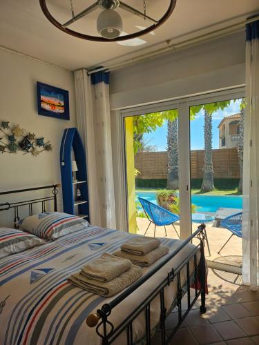 une chambre avec un lit et une porte coulissante en verre dans l'établissement Belle villa lespignan, à Lespignan