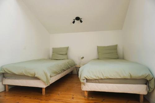 deux lits côte à côte dans une pièce dans l'établissement La Maison du Saunier entre mer et garrigue, à Lapalme