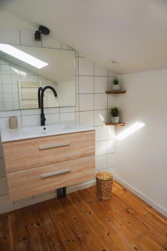 - une cuisine avec un évier et un miroir dans l'établissement La Maison du Saunier entre mer et garrigue, à Lapalme