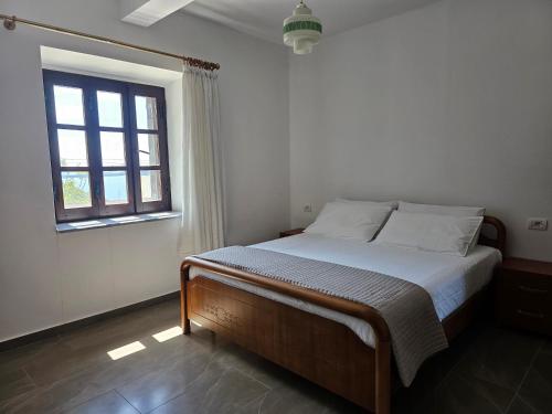 a bed in a bedroom with a window at Bliss Apartment in Qeparoi i Sipërm