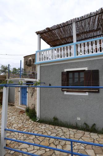 a house with a blue fence in front of it at Bliss Apartment in Qeparoi i Sipërm