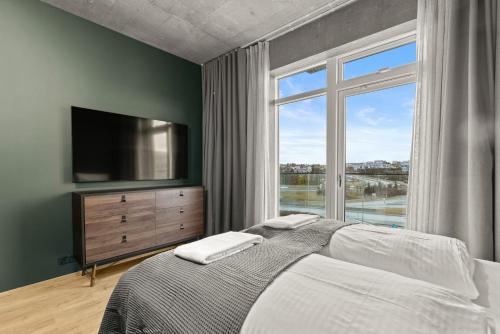 a bedroom with a bed and a large window at Aurora Nooks by Heimaleiga in Reykjavík