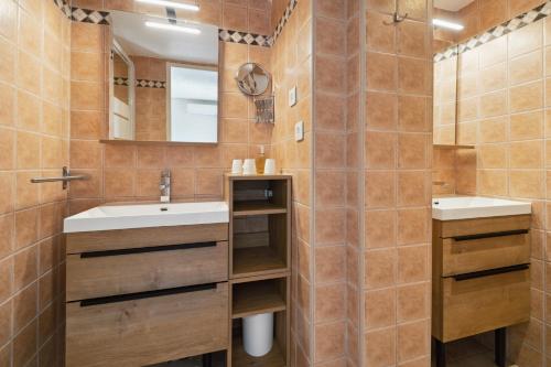 a bathroom with two sinks and a mirror at Hôtel La Nartelle in Sainte-Maxime