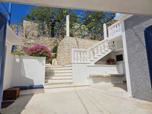 a stairway with white stairs and a stair case at Bliss Apartment in Qeparoi i Sipërm