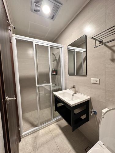 a bathroom with a shower and a sink and a mirror at Holi homestay in Houli