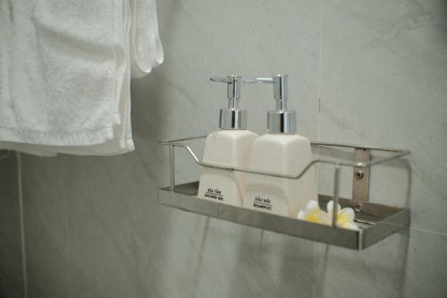 a bathroom with two soap dispensers on a shelf at IRIS HILL VILLA in Thôn Dương Xuân Hạ