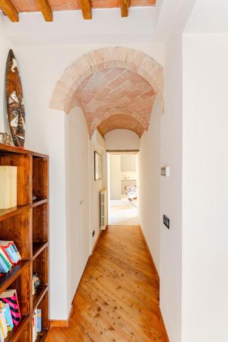 an archway in a room with white walls and wooden floors at Cosimo Charme in Chianti in Barberino di Val dʼElsa