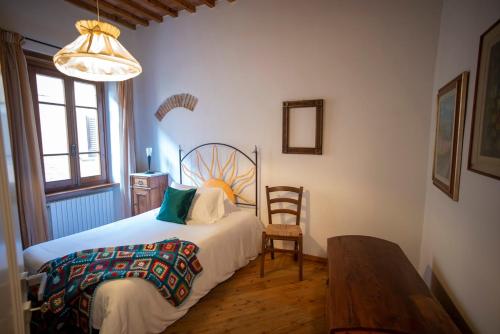 a bedroom with a bed and a table and a chair at Cosimo Charme in Chianti in Barberino di Val dʼElsa