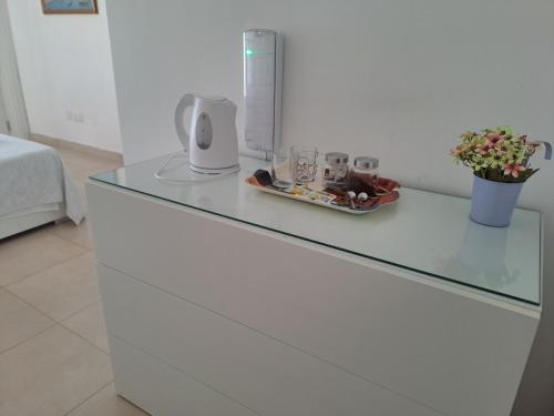 a white dresser with a glass counter top at Il-Qastna Holiday House in Żejtun