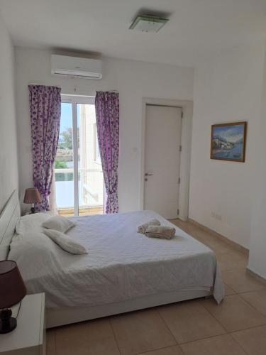 a bedroom with a large bed and a window at Il-Qastna Holiday House in Żejtun