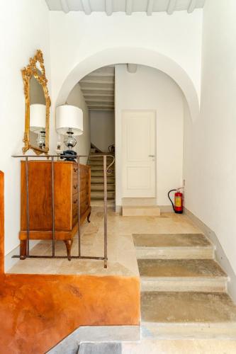a hallway with a mirror and a dresser and stairs at Cosimo Charme in Chianti in Barberino di Val dʼElsa