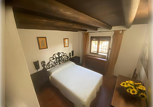 a bedroom with a bed and a table and a window at EL PUEBLO III -venga al pueblo- in Calañas