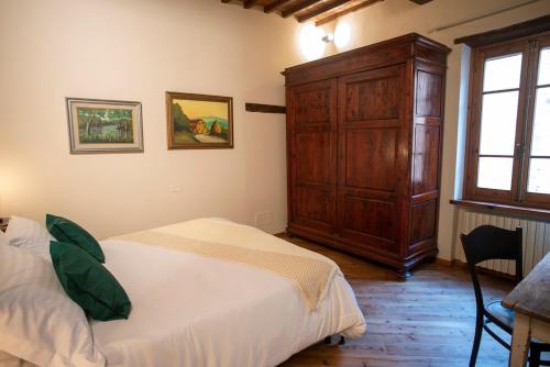 a bedroom with a bed and a wooden cabinet at Cosimo Charme in Chianti in Barberino di Val dʼElsa