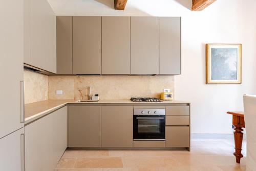 a kitchen with white cabinets and a stove at Cosimo Charme in Chianti in Barberino di Val dʼElsa