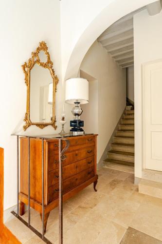 a mirror on a dresser in a hallway with a staircase at Cosimo Charme in Chianti in Barberino di Val dʼElsa