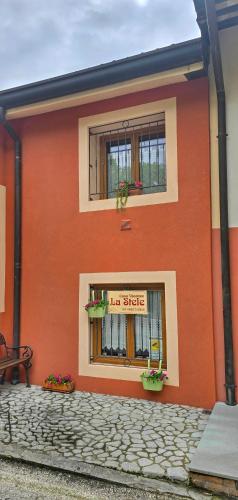 a orange building with a window and a sign on it at Casa Vacanze La Stele in Castelmonte