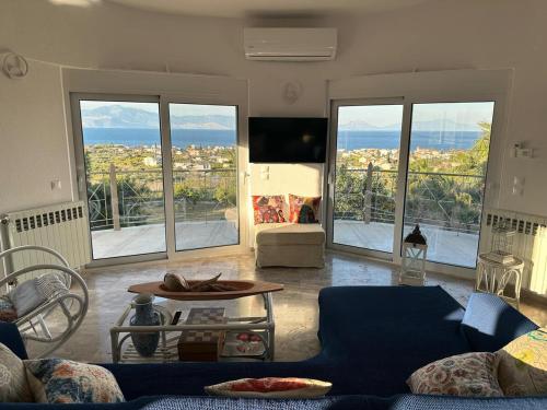 a living room with a blue couch and large windows at La maison des oliviers in Kiáton
