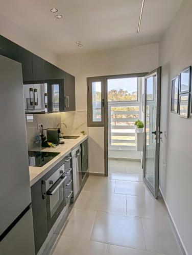 a kitchen with gray cabinets and a large window at EliteStay by Al Amir in Cabo Negro