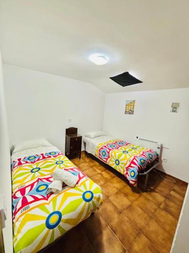 two beds sitting in a room with at La Casa de la Plaza in Rascafría