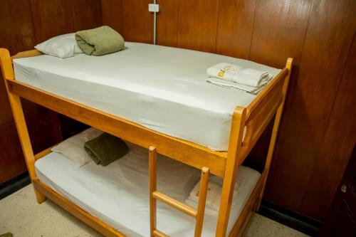 a bunk bed with white sheets and towels on it at Les Balcons Hostel in Popayan