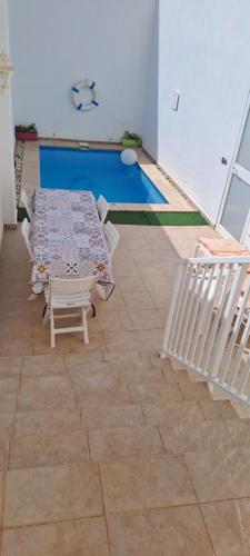 a room with a table and chairs and a pool at Il-Qastna Holiday House in Żejtun