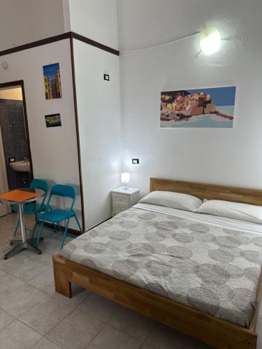 a bedroom with a bed and a table and chairs at Affittacamere l'Acciuga in La Spezia