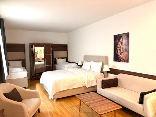 a hotel room with a bed and a couch at Akomo Bern in Bern
