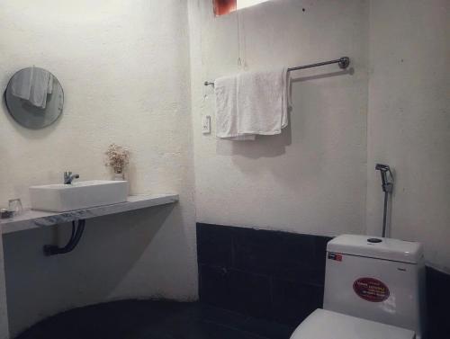 a bathroom with a white toilet and a sink at roc rach homestay in Ấp Tân Hà