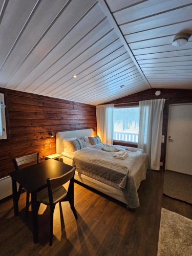 a bedroom with a bed and a table in it at North Frontier Studio Cabin in Saariselka
