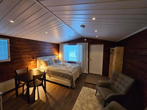a bedroom with a bed and a table and a chair at North Frontier Studio Cabin in Saariselka
