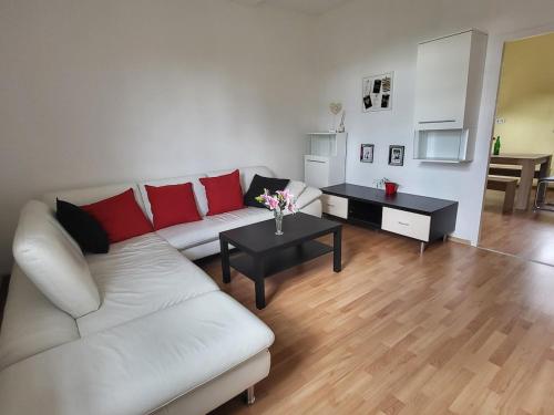 a living room with a white couch and red pillows at Ferienwohnung für 5 Personen in Breitenthal Nähe Idar-Oberstein in Breitenthal