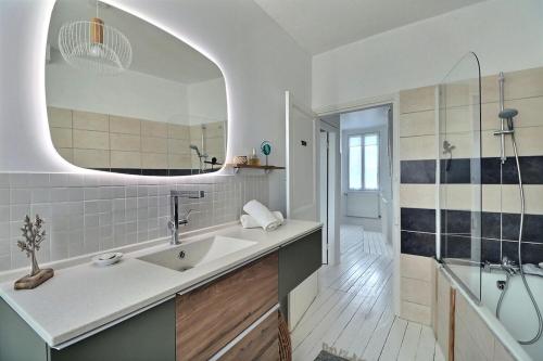 une salle de bain avec un lavabo et un miroir dans l'établissement L'endroit Valéricain, jardin, calme, centre, à Saint-Valery-sur-Somme