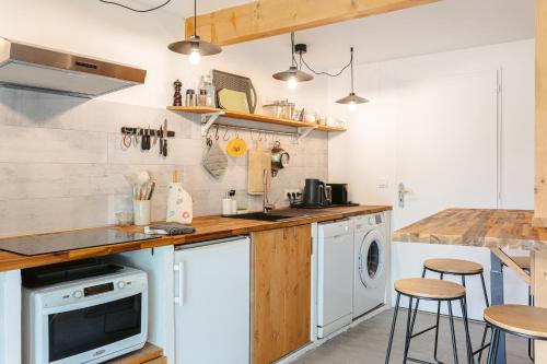 a kitchen with a sink and a dishwasher at Gabae Les Volets Verts in Puyravault