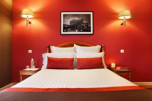 a bedroom with red walls and a bed with red pillows at Hotel Trianon Rive Gauche in Paris