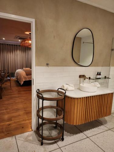 a bathroom with a counter with a sink and a mirror at Ochre and Ash in Clanwilliam