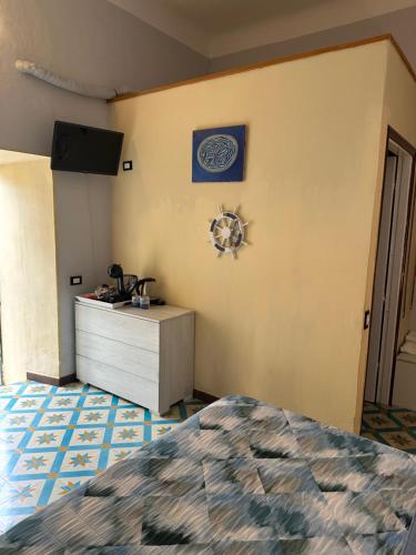 a bedroom with a bed and a dresser and a wall at Affittacamere l'Acciuga in La Spezia