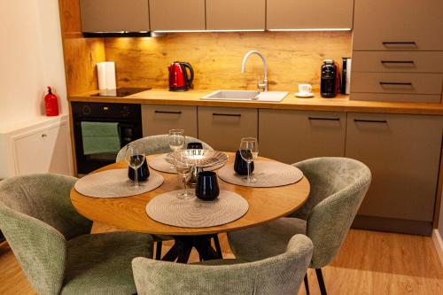 a kitchen with a table and chairs with wine glasses at Alpine Nest Grand Chalet in Poiana Brasov