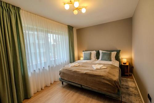 a bedroom with a bed and a large window at Alpine Nest Grand Chalet in Poiana Brasov