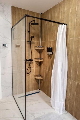 a shower with a glass door in a bathroom at Alpine Nest Grand Chalet in Poiana Brasov