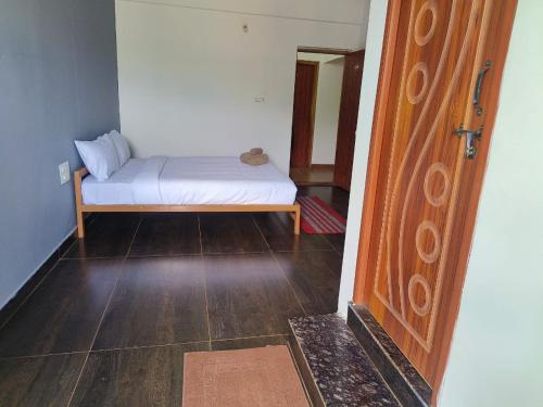 a small bedroom with a bed in a room at The Natures Nest Resort in Attigundi