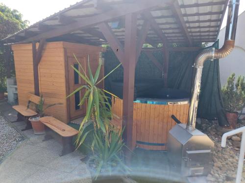 a gazebo with a hot tub and a bench at Csopaki Hajós Apartman in Csopak